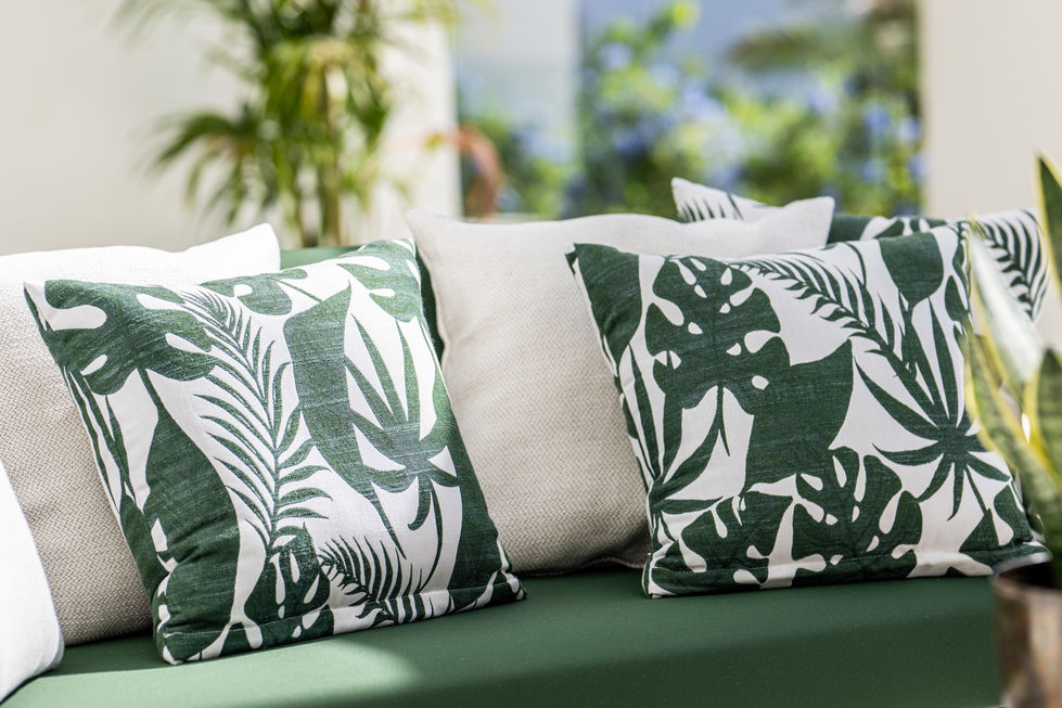 green and white pillows on a green couch