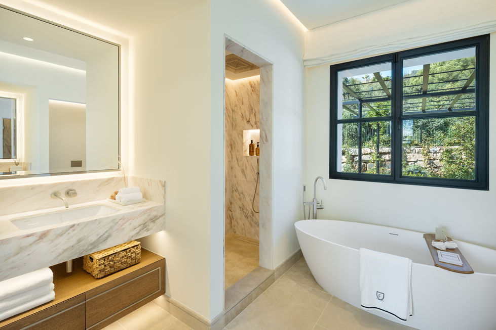 a bathroom with a tub a sink and a window