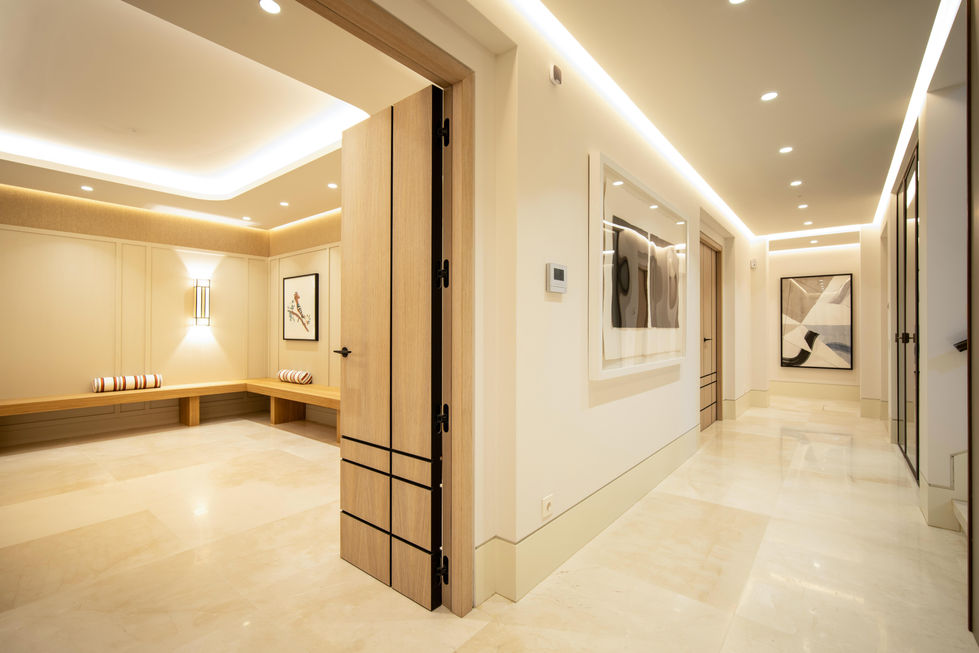 a hallway with paintings on the wall and a thermostat on the wall
