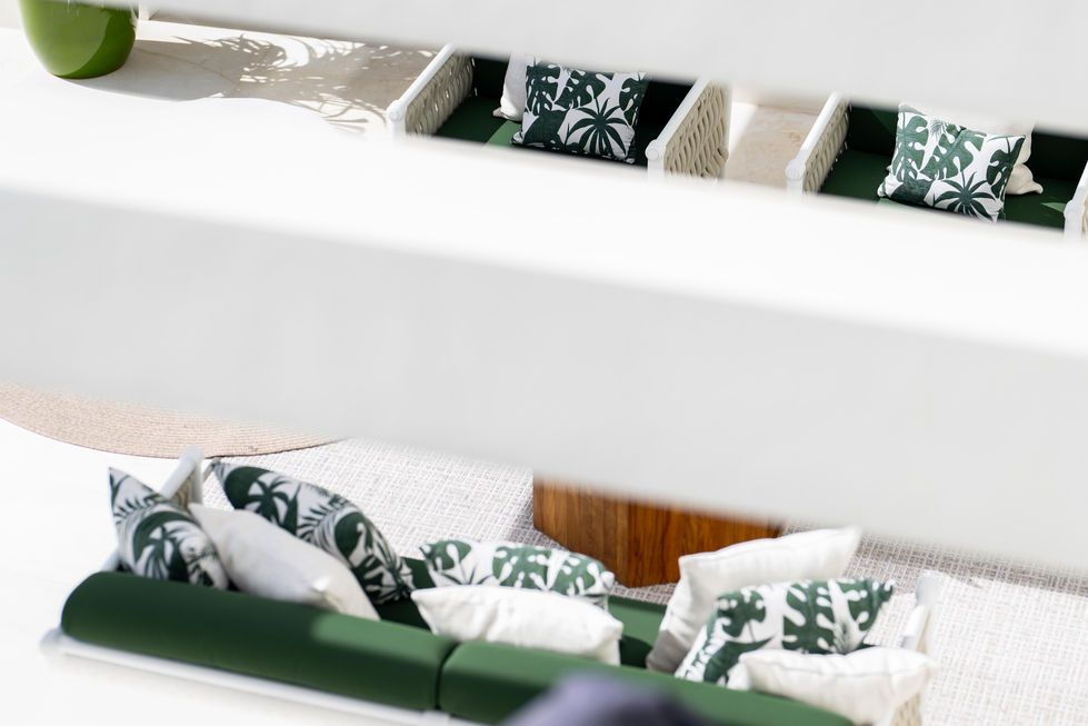 a couch with green cushions and white pillows