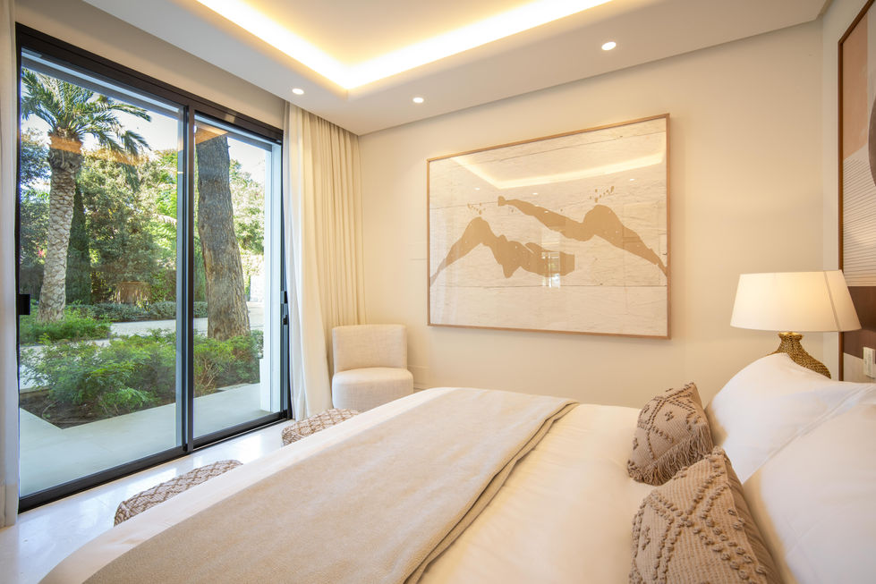 a bedroom with a large painting on the wall above the bed