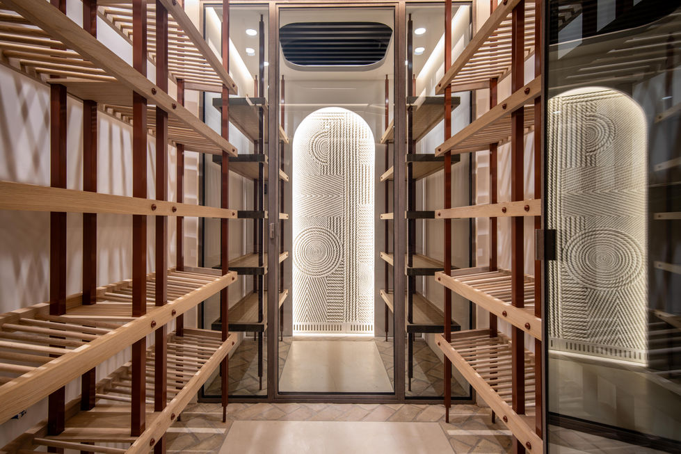a wine cellar with wooden shelves and a glass door