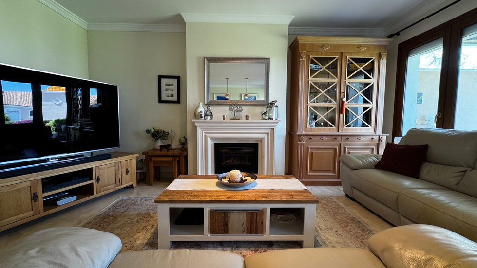 Cozy living room with fireplace and wooden furniture.