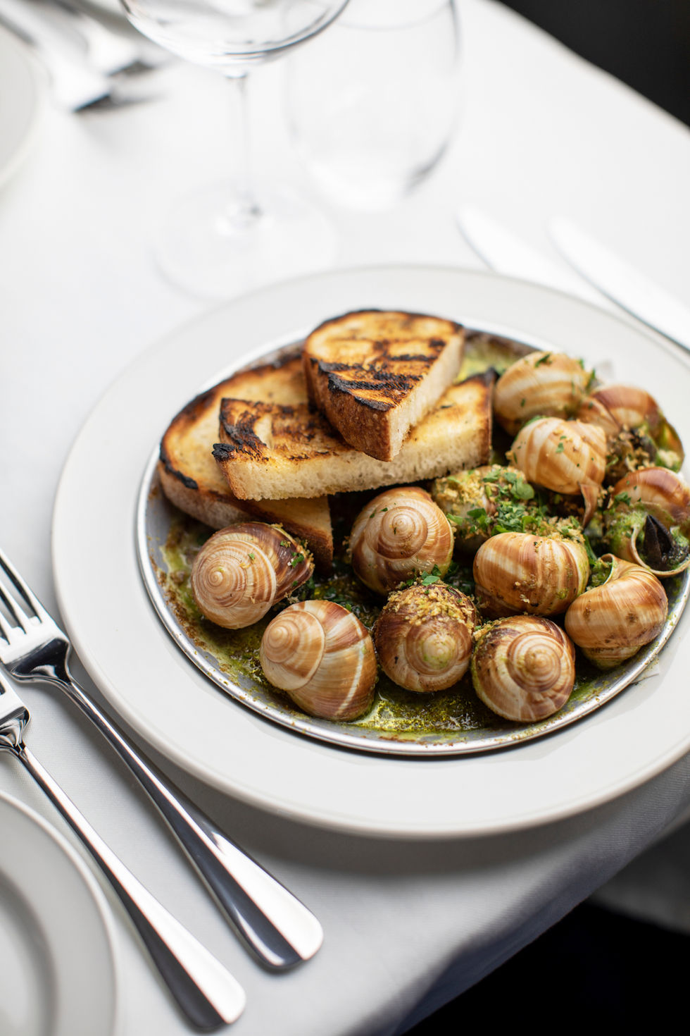 a plate of food with snails and bread on it