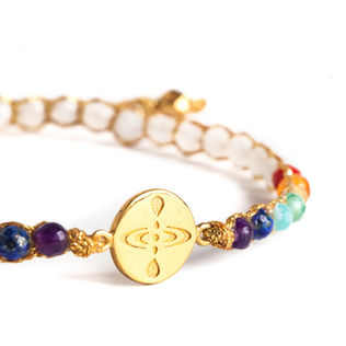 Beaded bracelet, gold engraved charm, vibrant chakra colors, white beads.