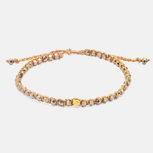 Adjustable cord bracelet with small beads and one central gold square bead.