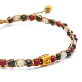 Beaded bracelet featuring red, black, white beads and gold rectangular element.