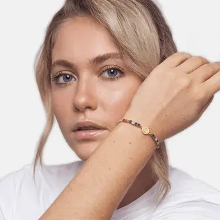 Blonde woman wearing elegant Inclusiveness Bracelet Gold on her wrist.