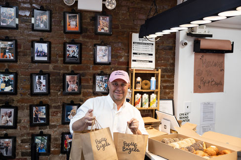 Image of someone holding 2 bags of PopUp Bagels