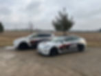 view of two cars parked in a field