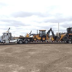 A large trailer with 2 heavy equipment loaded on the back