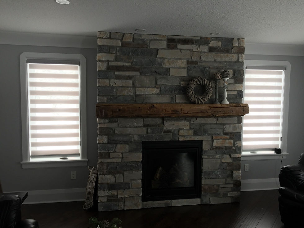 A fireplace flanked by two windows covered with day and night blinds