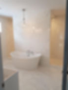 View of a modern bathroom with patterned tiles on the floor and walls