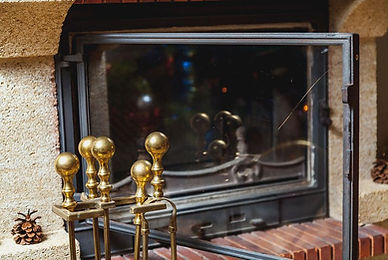 set of brass tools stands in front of fireplace