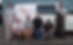 team posing in front of van