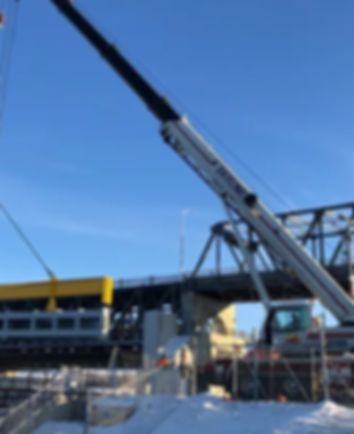A crane is hoisting massive steel beams.