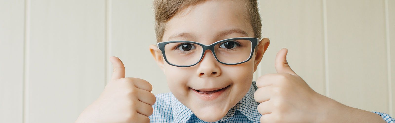 Boy with glasses showing two thumbs up
