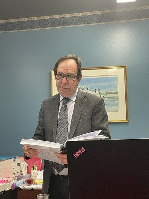 Une photo de Me Jean J. Laflamme qui tient un dossier dans un bureau