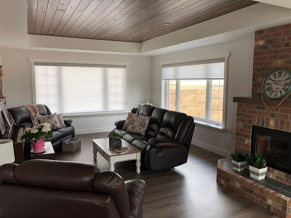 Wide living room windows that are either partially or fully covered by white blackout window blinds