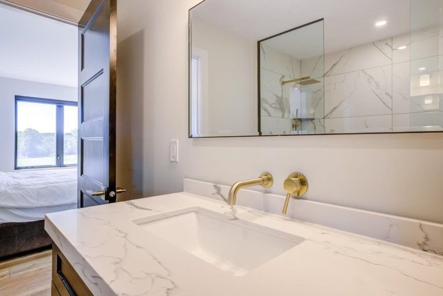 A picture of bathroom with white-coloured sink and a mirror