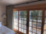 Close-up of a window door leading to the balcony with curtains set aside on the left corner.