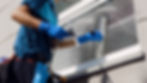 Male professional cleaning the windows of a store with special equipment