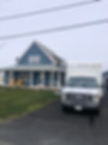 A picture showcasing an under constructed blue-coloured house and a vehicle parked on the driveway