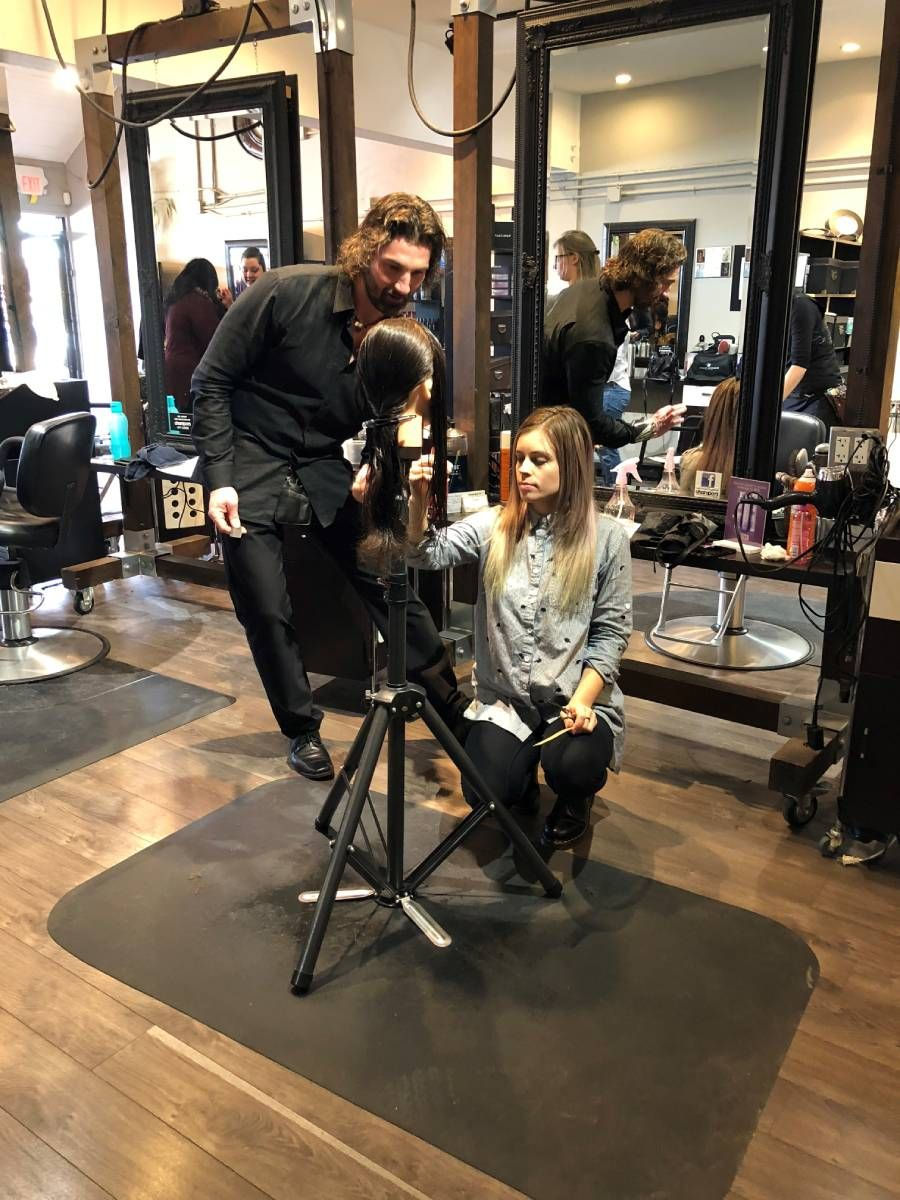 young girl practicing hair styling in front of an experienced hairstylist