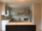 A white countertop with white kitchen cabinets in the background