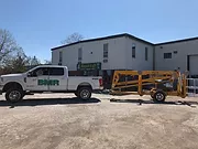 A white mini truck in front of a building