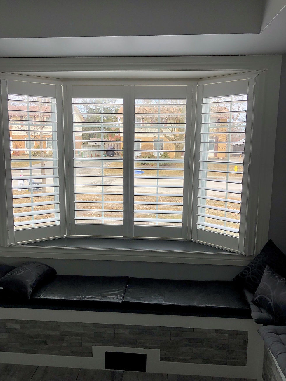 Front view of a concave window arrangement using white shutters that are partially open