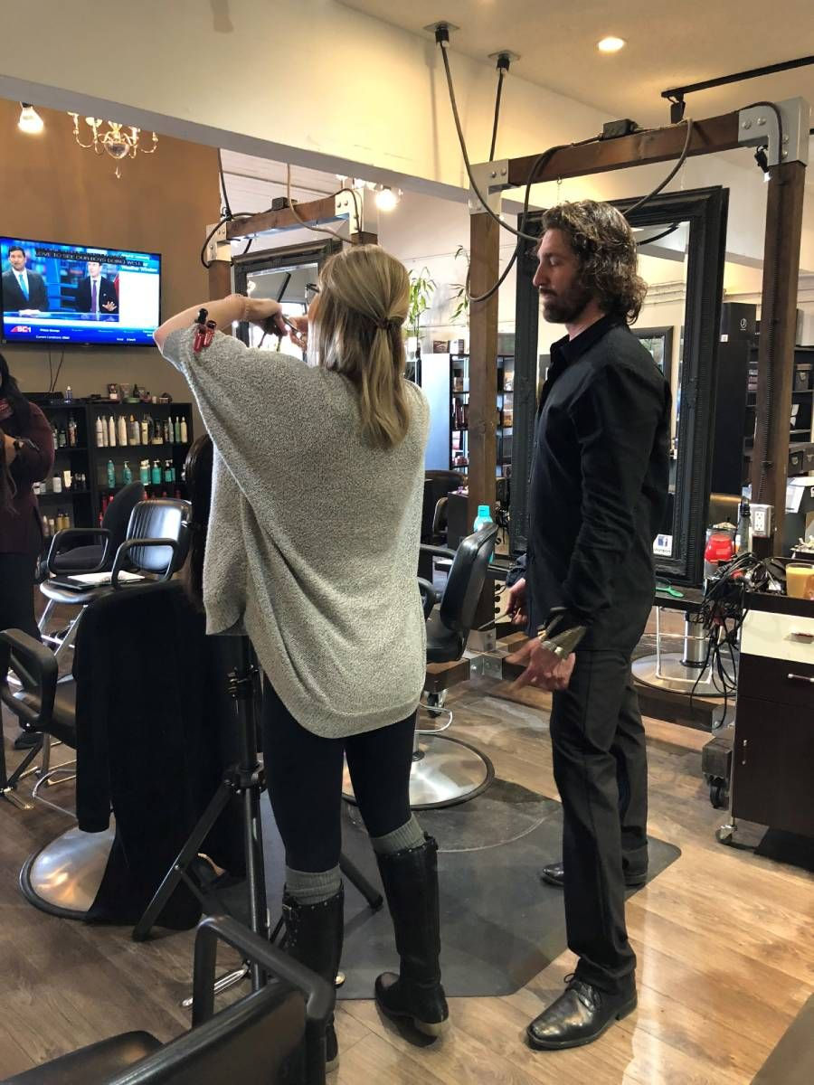 hairstylist helping a woman stylist in styling hair