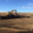 excavator digging a hill of dirt