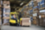 Worker lifting a stock of boxes inside a warehouse