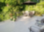 view of a deck with flower pots and wooden furniture