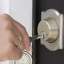 man opening the door lock with a key
