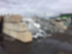 steel scrap bin surrounded by multiple big concrete bricks
