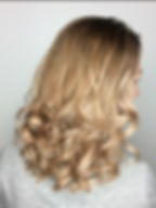 angled image of a woman with curly blonde hairs