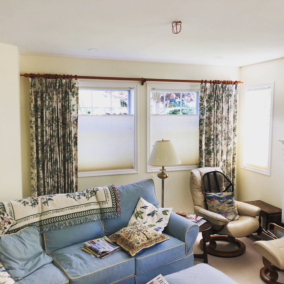 A fully packed room with a blue couch and lamps kept against the wall with designer curtains on either side.