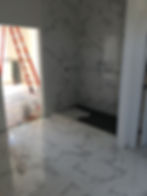 Interior view of a room under construction with patterned tiles on the floor and wall