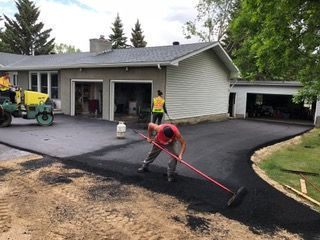 men spreading asphalt on road