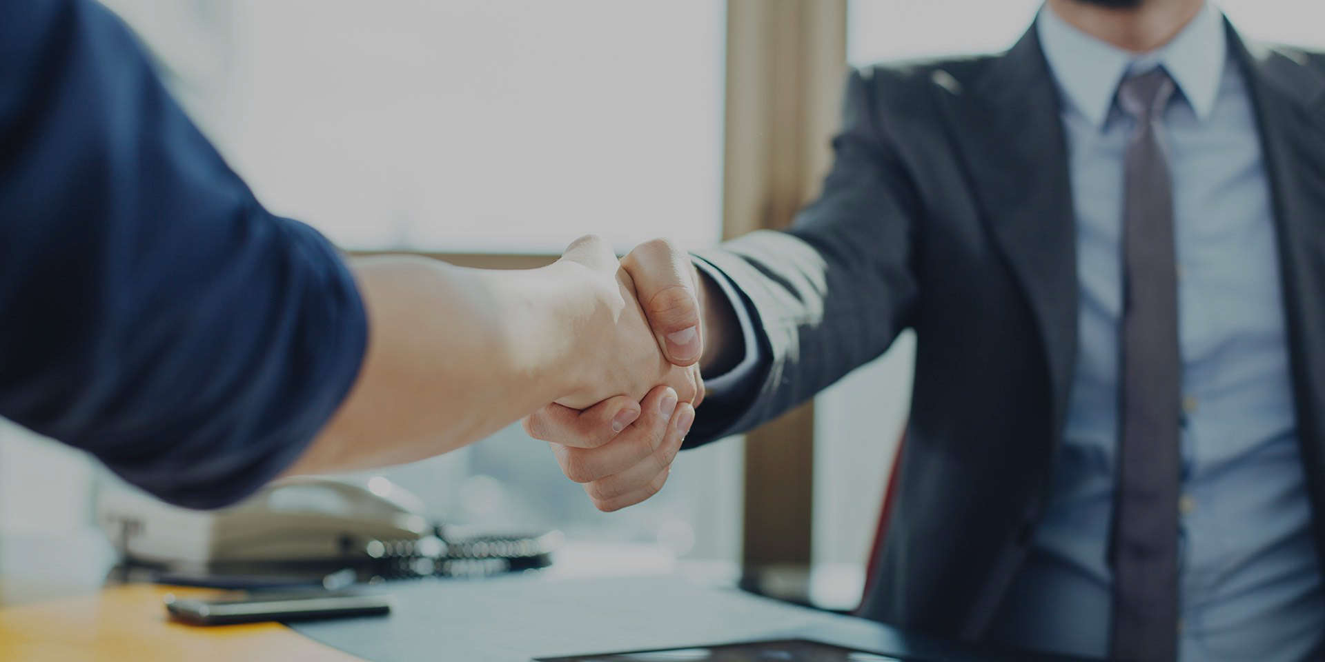 male lawyer shaking hands with client in office