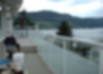 View of a deck with glass railings and mountains in background