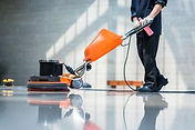 person cleaning floor with machine