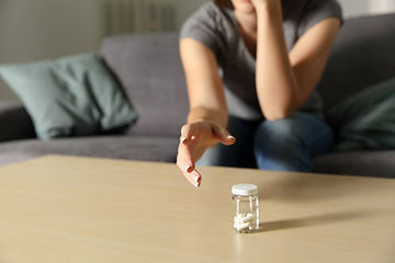 lady reaching out to pick up medicines