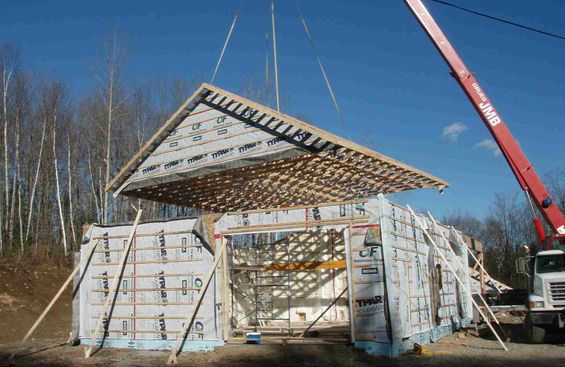 Installation de poutres de soutien en bois sur une maison en construction