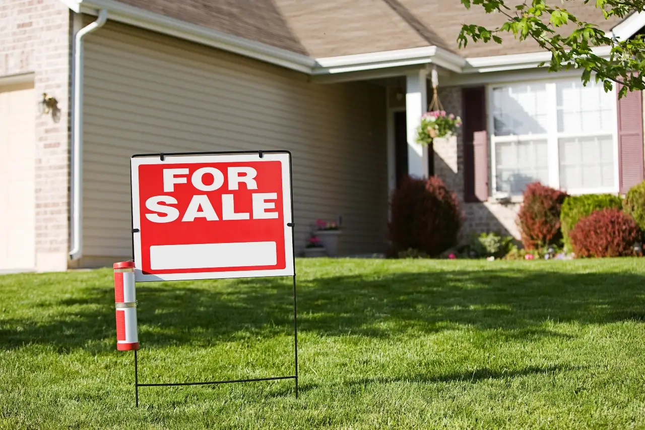 for sale sign in front of a house