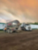 wide angle view of vacuum trucks and a worker in the ground