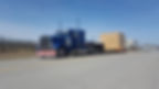 Camion remorqueur bleu transportant un conteneur en bois