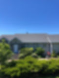 A photo of a big roof house surrounder by greenery